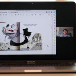 Laptop open with e-book and webcam.