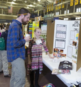 Young girl explaining a science fair project.