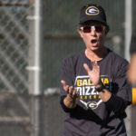 Carol clapping while wearing a cap and t-shirt