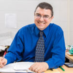 Jason smiling while seated at a desk