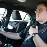 Jason in uniform while in the driver's seat of a police vehicle