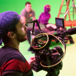 Camera Operator filming on a green screen set