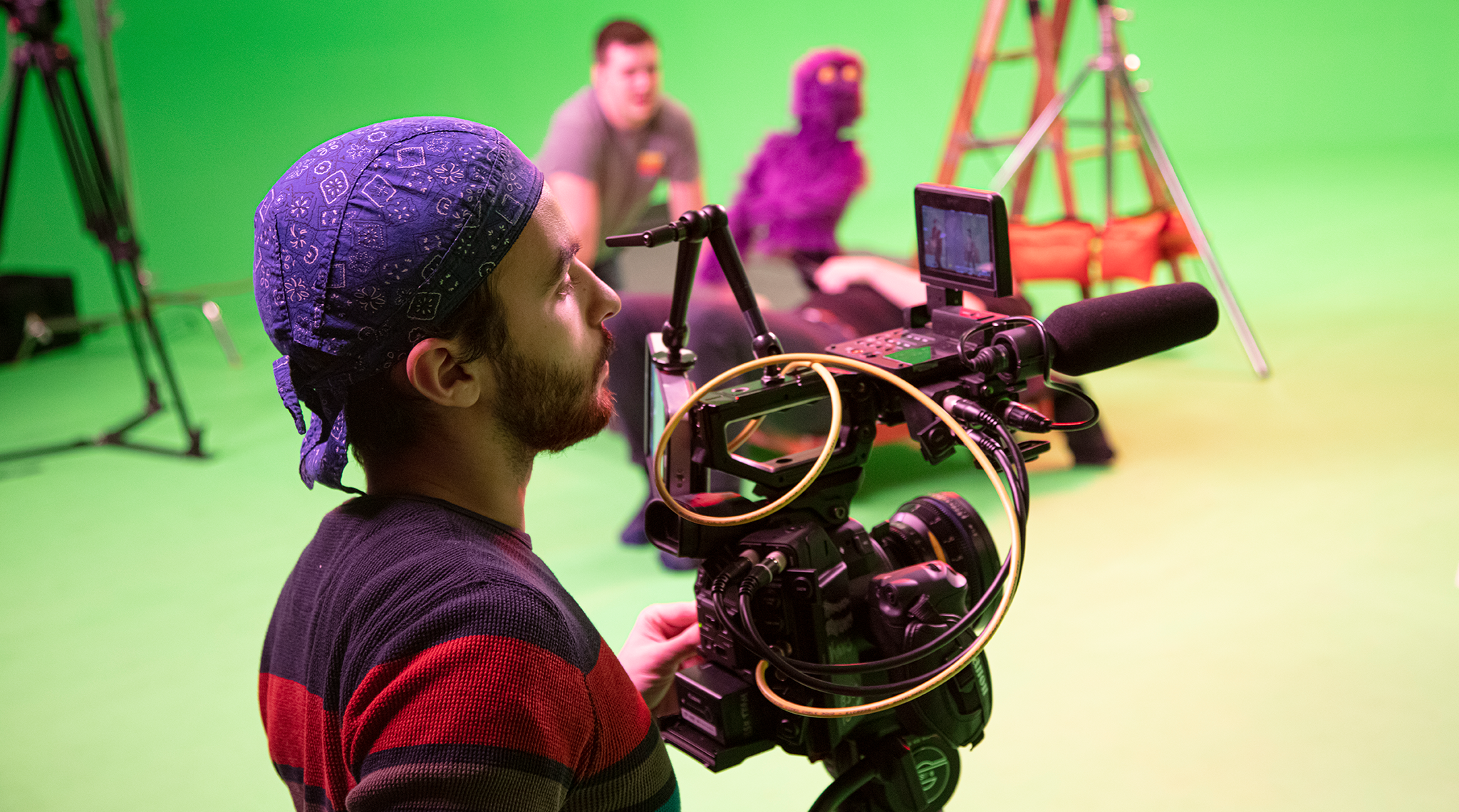 Camera Operator filming on a green screen set