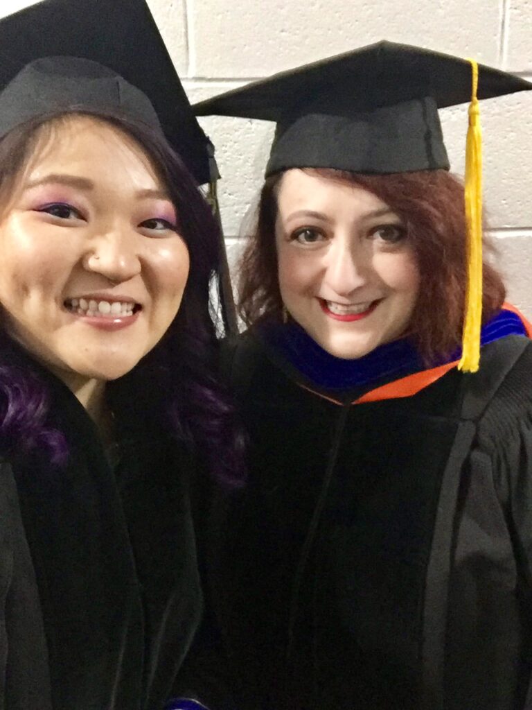 Dr. Hester standing next to a friend in their caps and gowns.