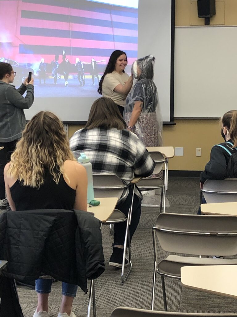 Dr. Hester getting a pie to the face by a student in class.